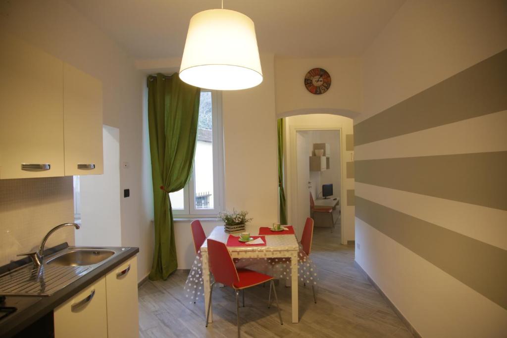 una cucina e una sala da pranzo con tavolo e sedie di Casa San Vincenzo, un nido nel cuore di Genova. a Genova
