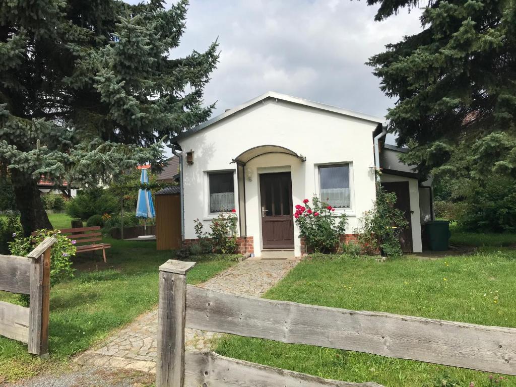 a white house with a fence in front of it at Ferienhaus am Kaltenstein in Olbersdorf