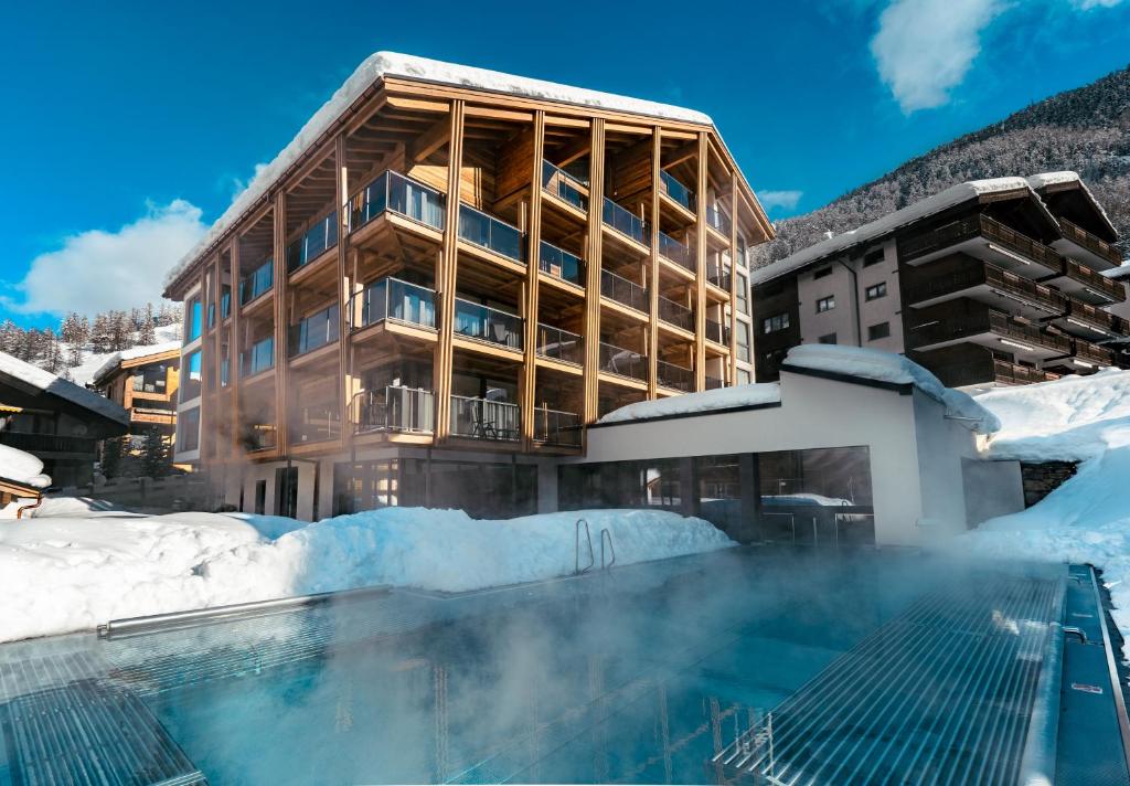 a hotel with a swimming pool in the snow at Resort La Ginabelle in Zermatt