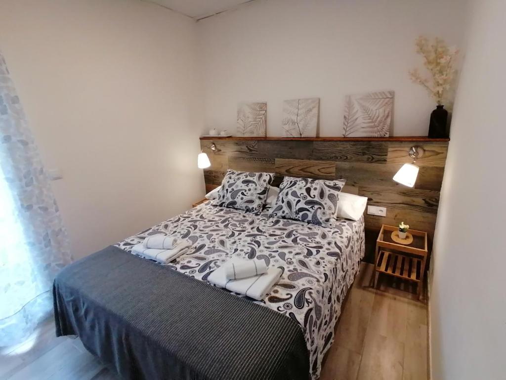 een slaapkamer met een bed met een houten hoofdeinde bij Gelvesturist 2 in Gelves
