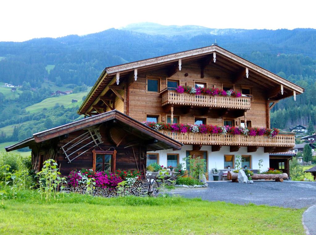 una casa in legno con fiori sul balcone di Ferienwohnung Lerchenhof a Wald im Pinzgau