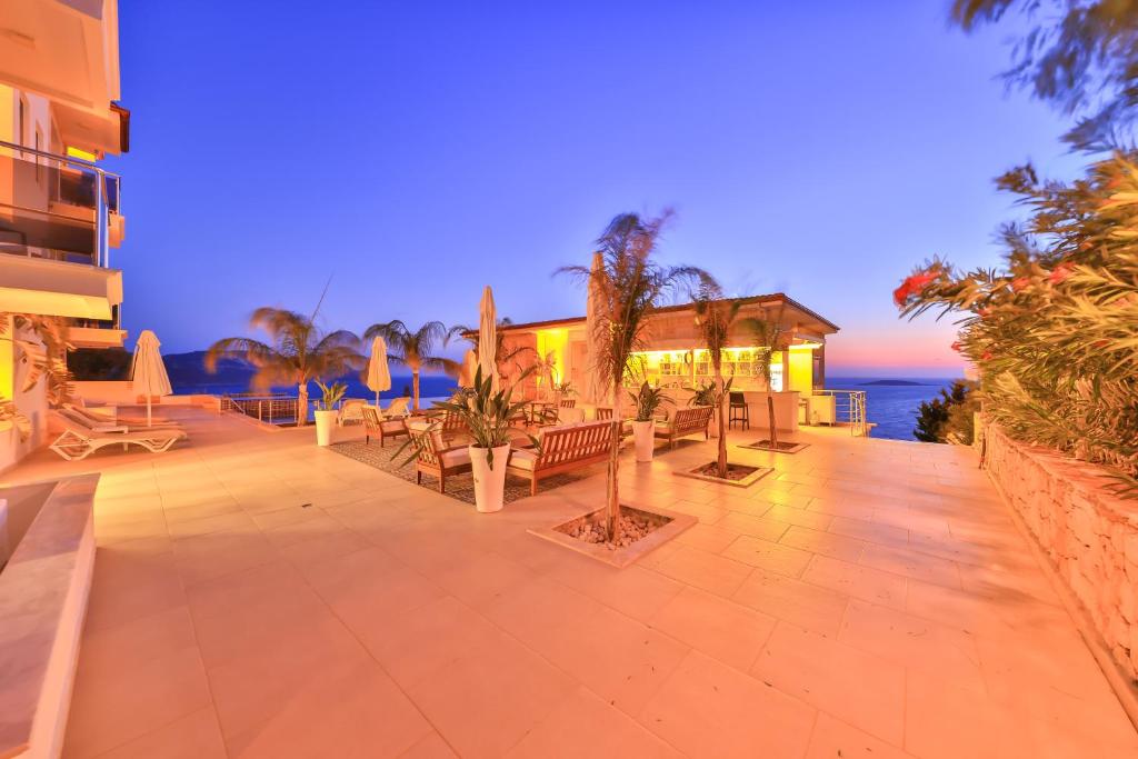 a patio with tables and chairs and the ocean at La Kumsal Hotel in Kaş