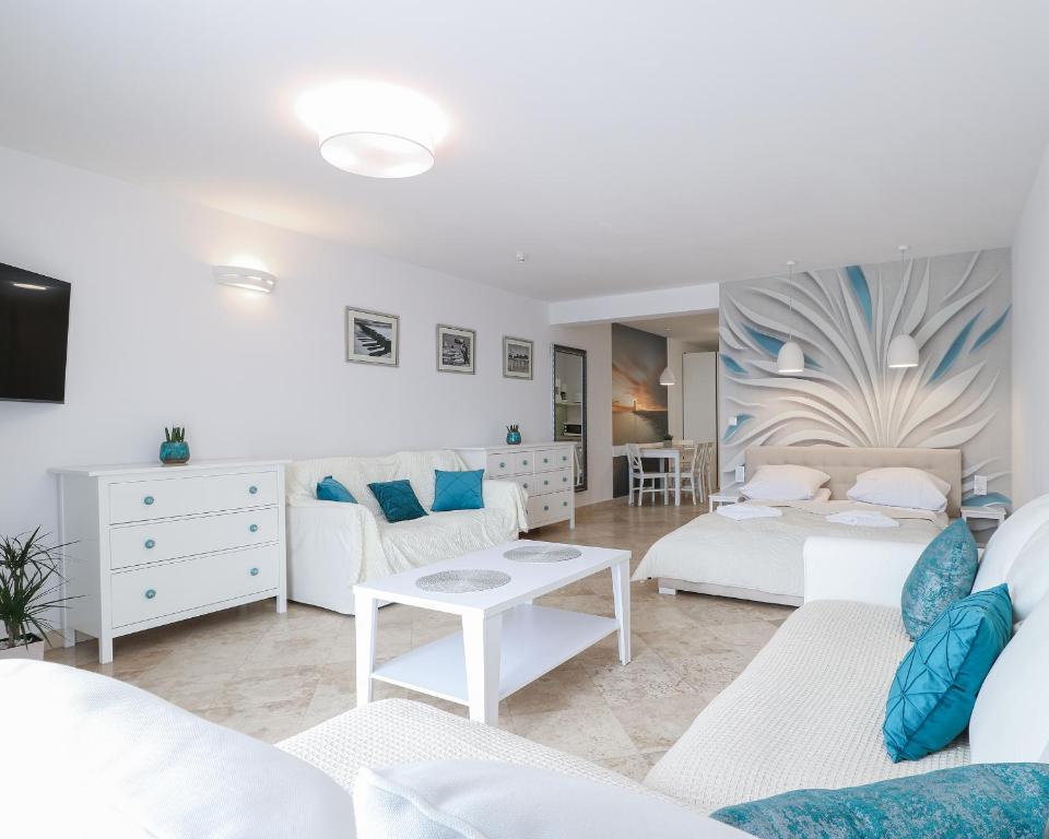 sala de estar con muebles blancos y detalles en azul en Morski Anioł by Baltic Home en Świnoujście