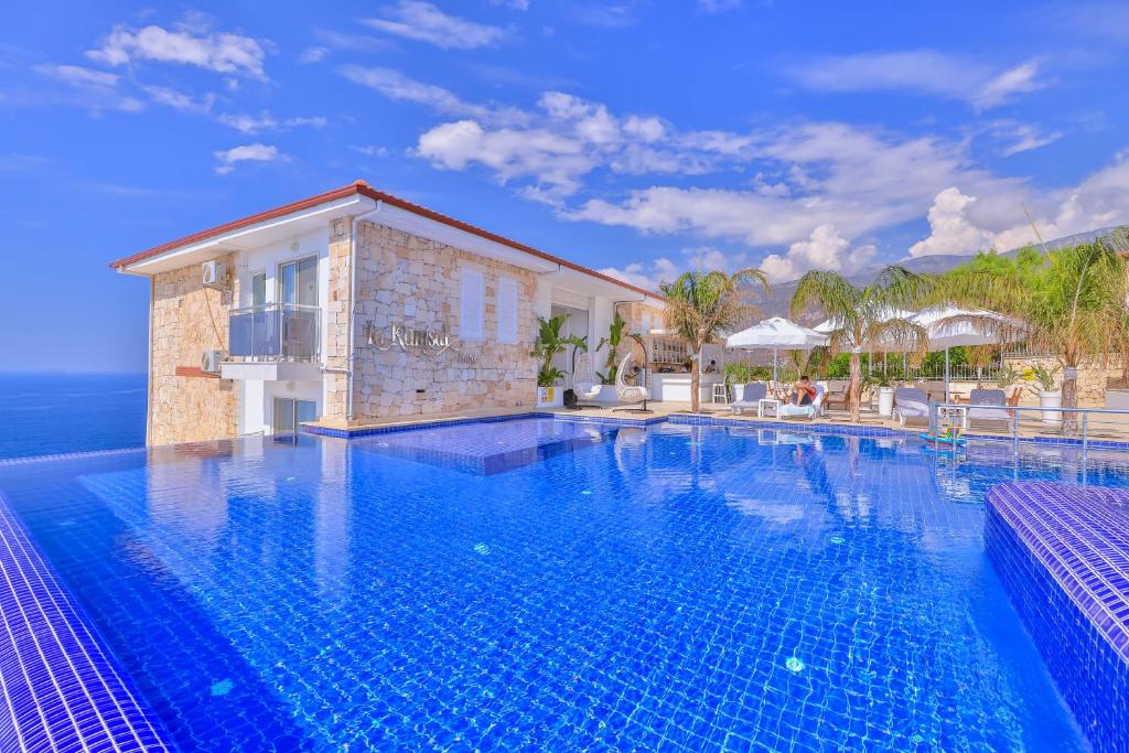 a swimming pool in front of a villa at La Kumsal Hotel in Kaş