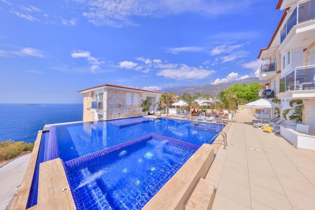 a swimming pool with a view of the ocean at La Kumsal Hotel in Kaş