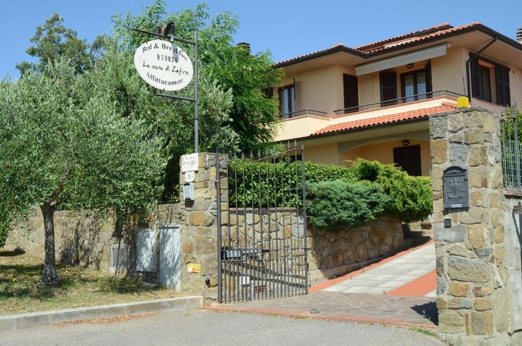 a sign in front of a house with a gate at B&B La Casa Di Zefiro in Limite