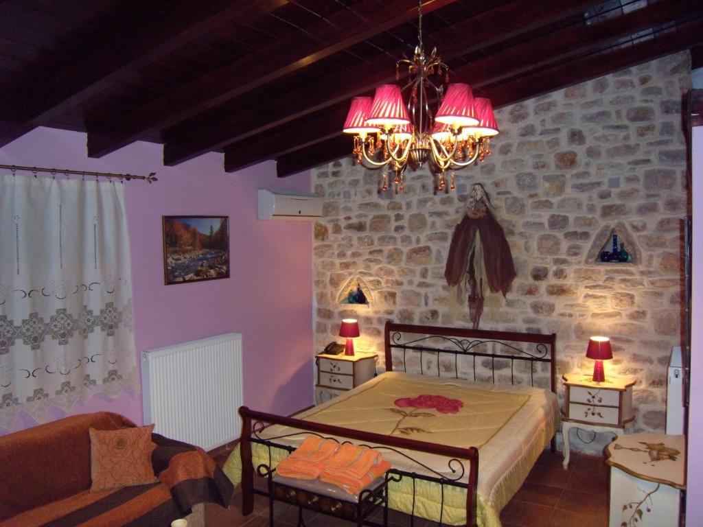 a bedroom with a bed and a stone wall at Mountain Ηouse in Arcadia in Vitina