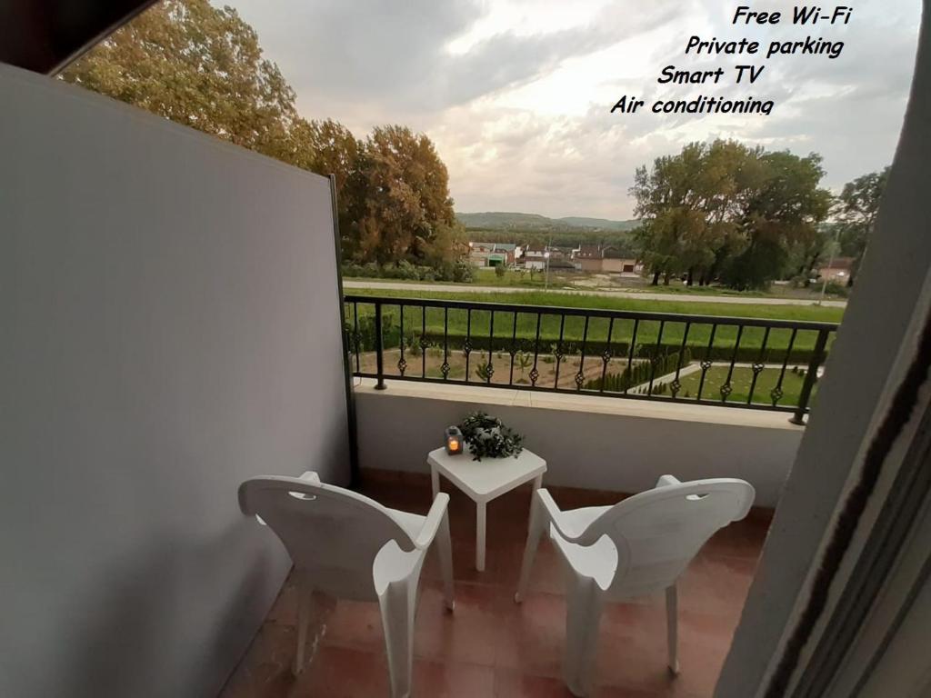 een balkon met 2 stoelen en een tafel met uitzicht bij Apartman Joy in Pasuljište