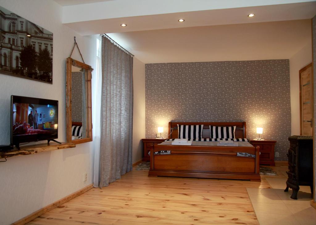 a bedroom with a bed and a tv on a wall at Emilie's Apartments in Liepāja