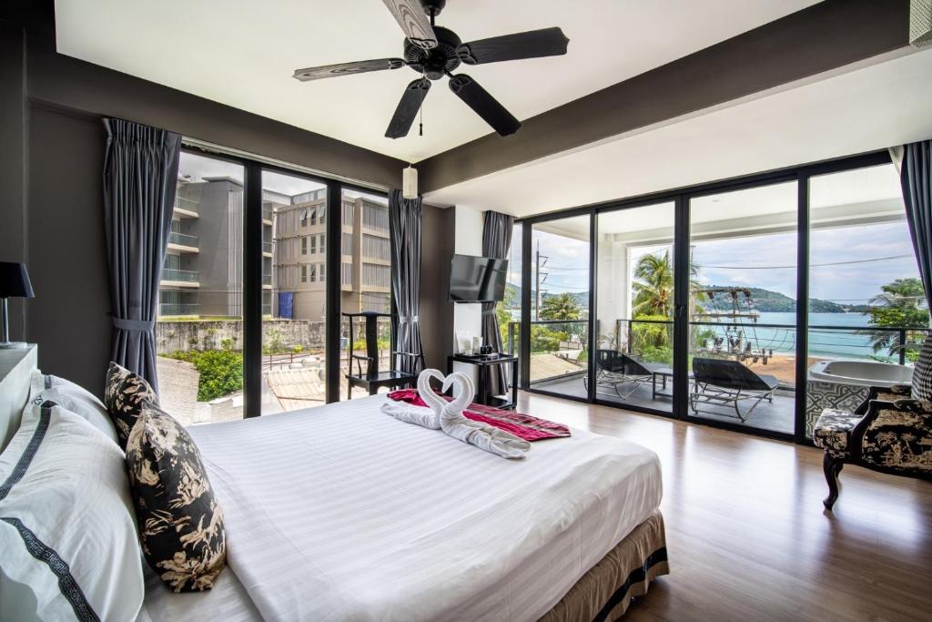 a bedroom with a large bed and a large window at See Sea Villa Phuket SHA in Patong Beach