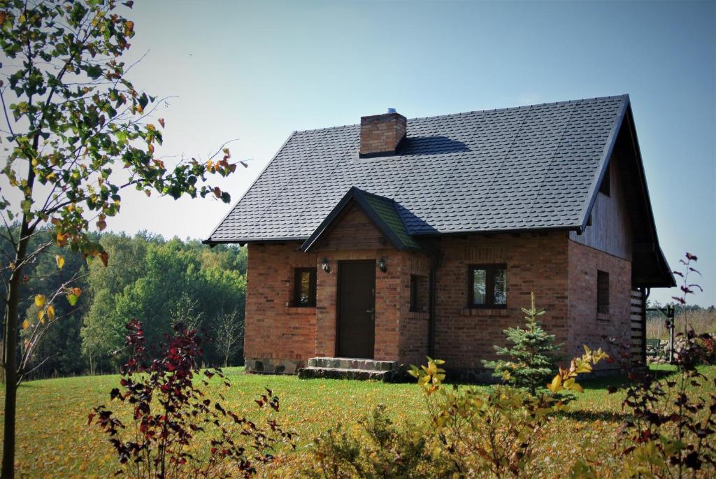 ein kleines Backsteinhaus mit schwarzem Dach in der Unterkunft Kartkówka in Unichowo