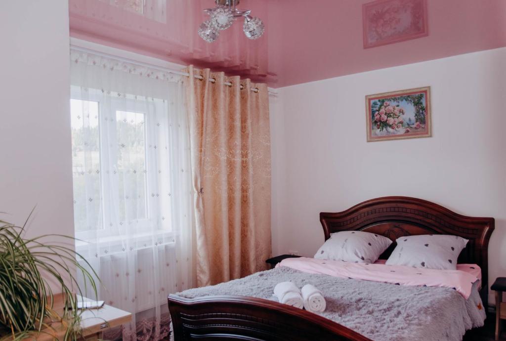 1 dormitorio con 1 cama y 2 toallas blancas en Family House Volosianka, en Volosyanka