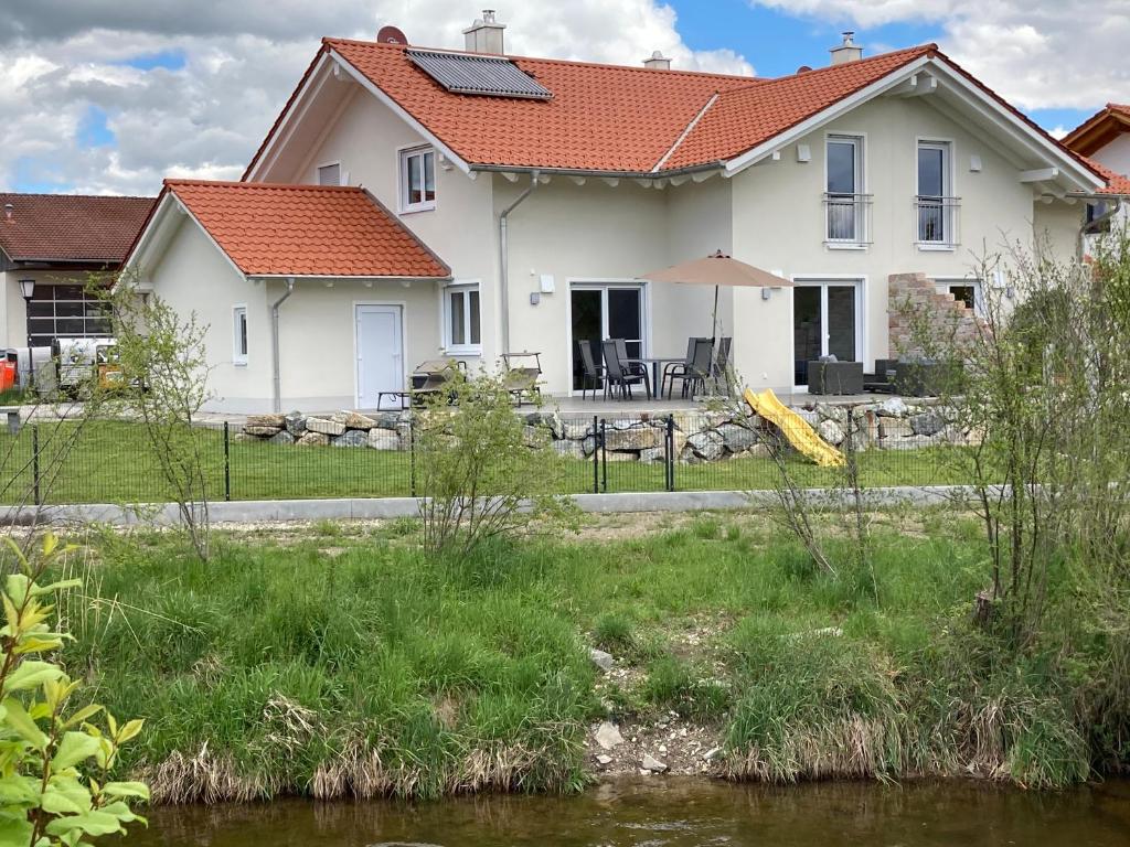 Ferienwohnung an der Ach في Oberhausen: منزل أمامه نهر