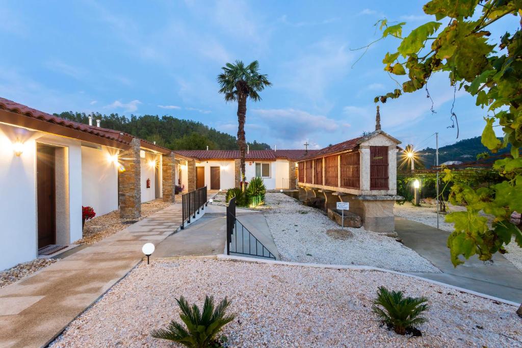 a house with a courtyard and a palm tree at Hotel Donas e Cabaleiros in Pousada