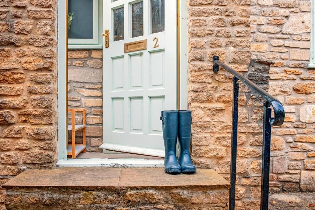 a pair of boots sitting on the doorstep of a door at 2 The Old Stables in Tetbury
