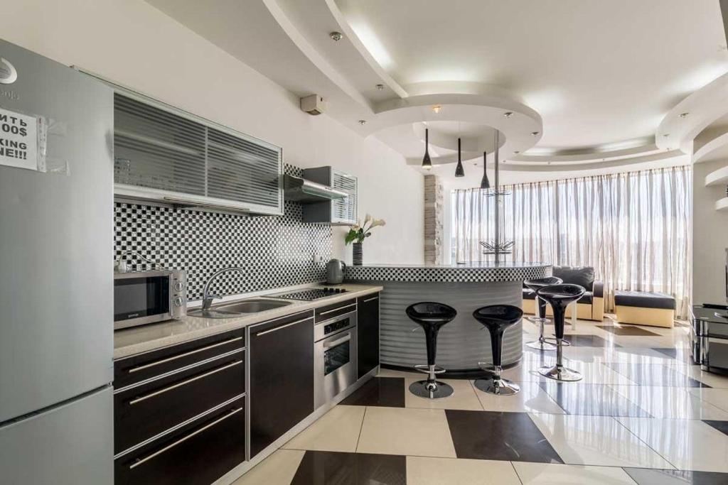 una cucina con bancone e due sgabelli di Cozy Apartment in Most City Center a Dnipro