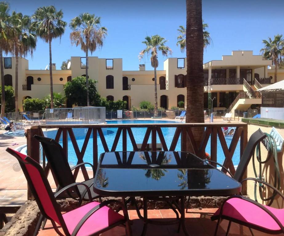 een tafel en stoelen voor het zwembad bij STUDIO TAGORO in Costa Del Silencio