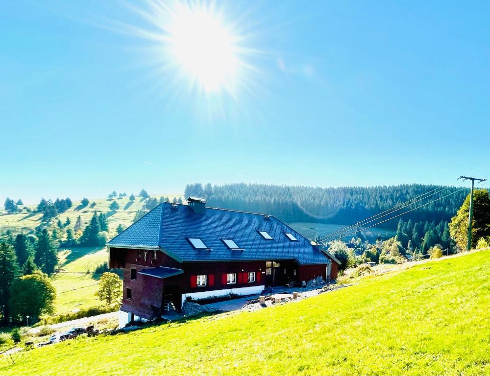 Eine Scheune auf einem Hügel mit der Sonne am Himmel in der Unterkunft RotmeerHaus in Feldberg