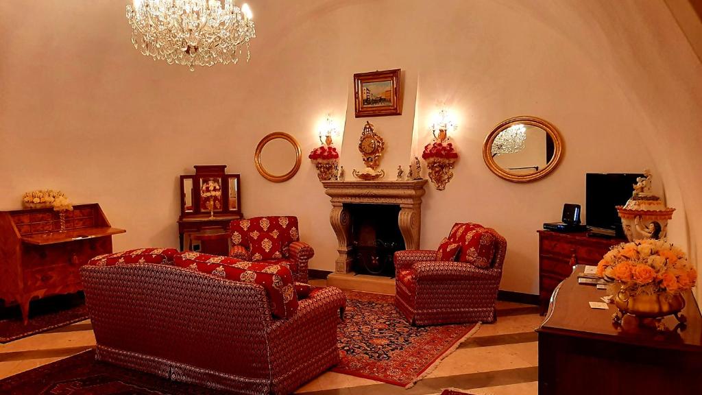 uma sala de estar com cadeiras, uma lareira e um lustre em Casa Giulia em Rodengo Saiano