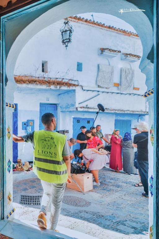 a man walking through a doorway with a group of people at RIAD LA SANTA in Chefchaouen
