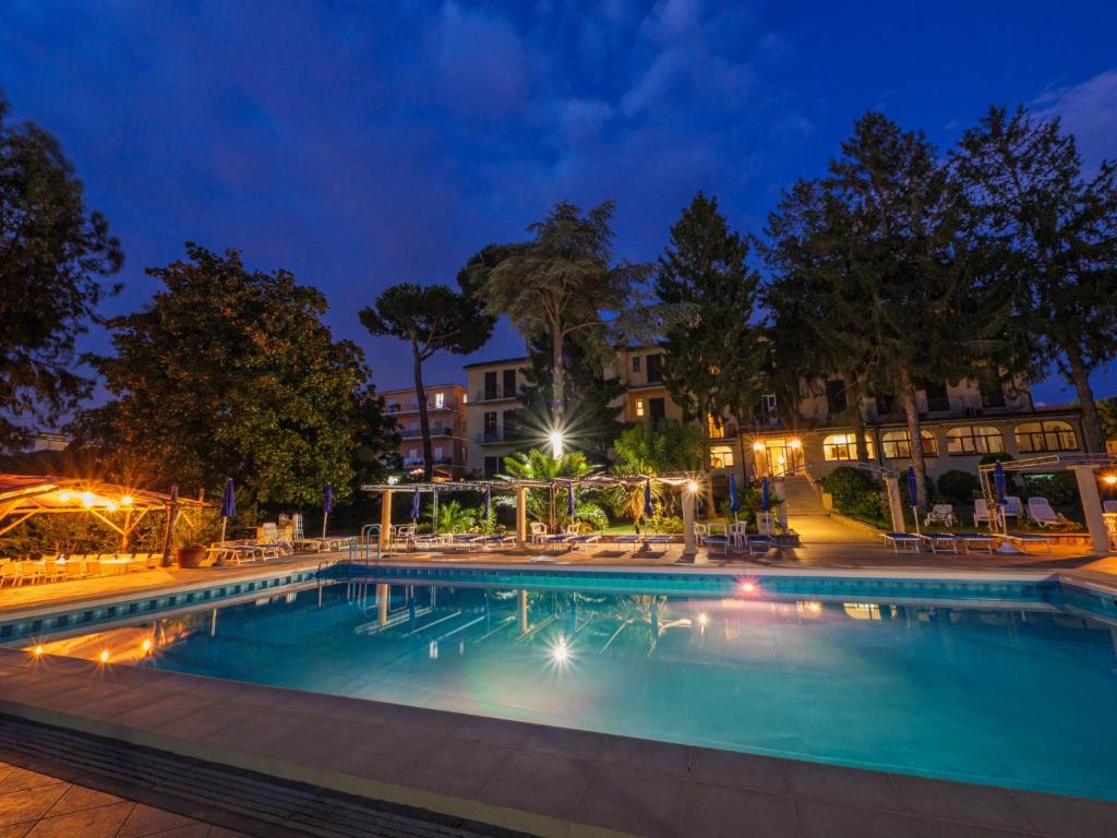 una piscina por la noche con luces en Hotel Delle Palme, en SantʼAgata sui Due Golfi