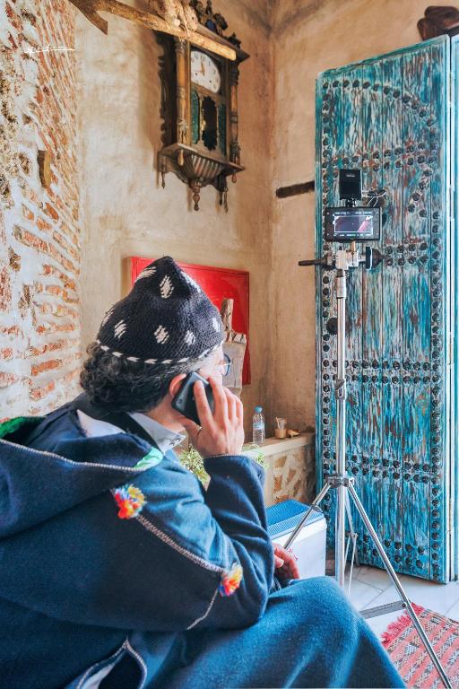 a man talking on a cell phone in a room at RIAD LA SANTA in Chefchaouen