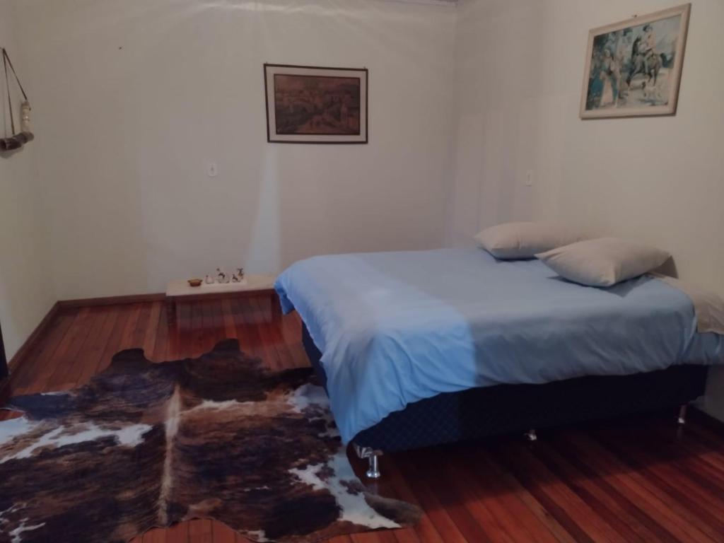 um quarto com uma cama e piso em madeira em Casa de Campo - Cambará do Sul em Cambará