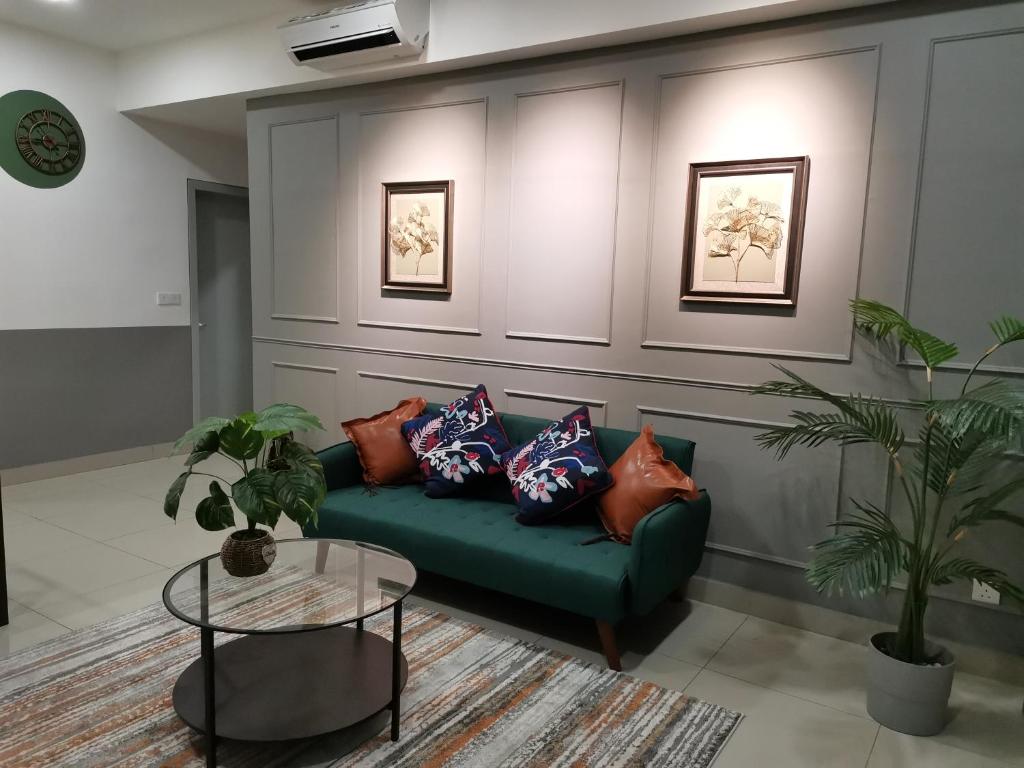 a living room with a green couch with pillows at HIJAU Geniehome 2BR1studio Free 99mbps WIFI and Carpark at Utropolis Shah Alam in Shah Alam
