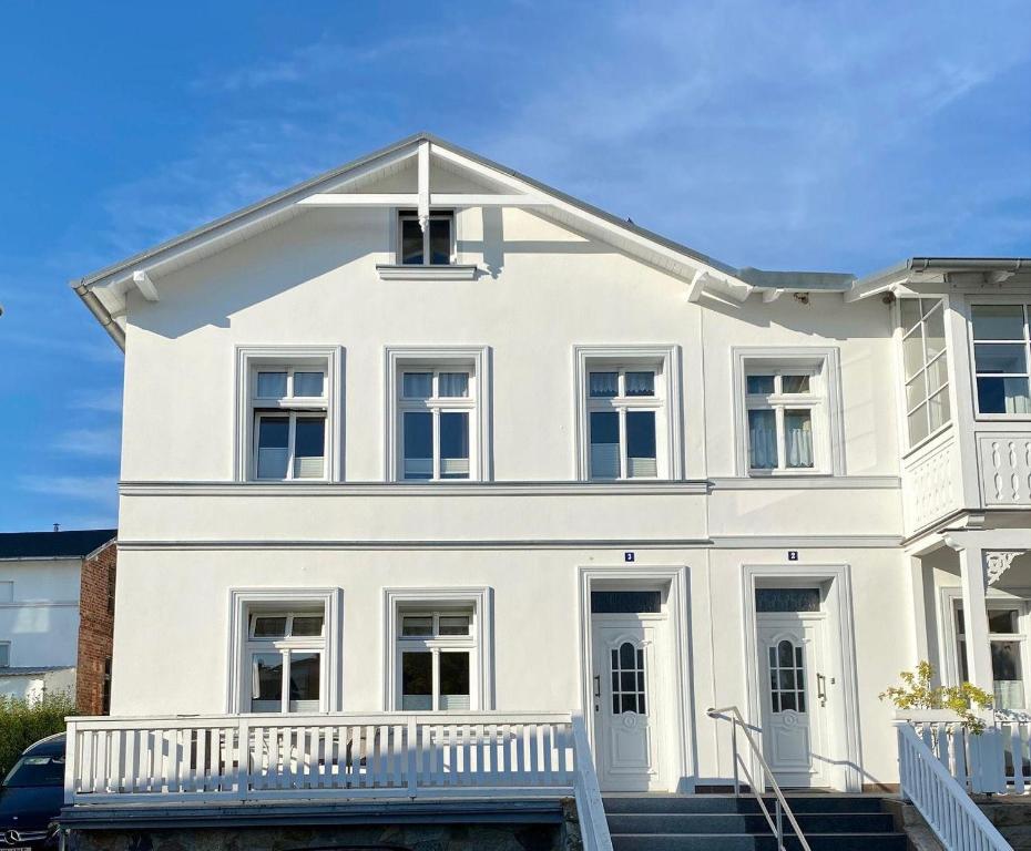 a white house with a white porch at Ferienwohnung-2-in-der-Altstadt-Fam-Harder in Sassnitz