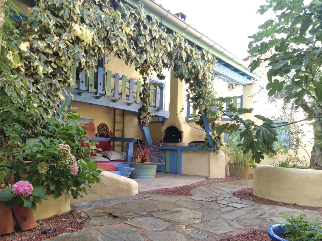 een huis met een patio met planten en bloemen bij Chez Gillou in Boën