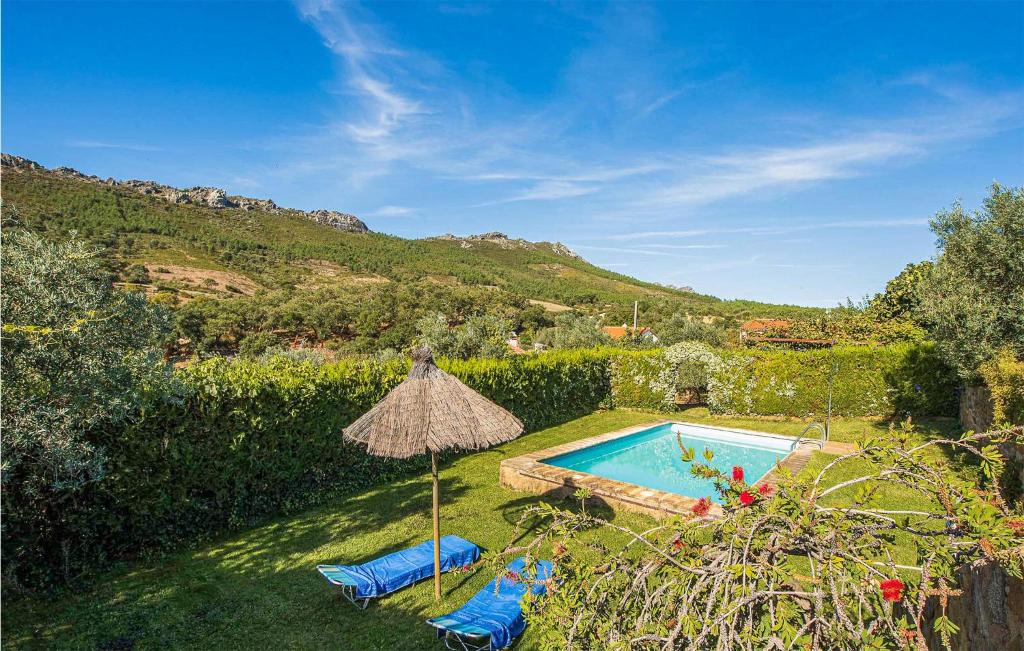una piscina con 2 sillas y una sombrilla en Amazing Home In La Acea De La Borrega With Outdoor Swimming Pool, en La Aceña de la Borrega