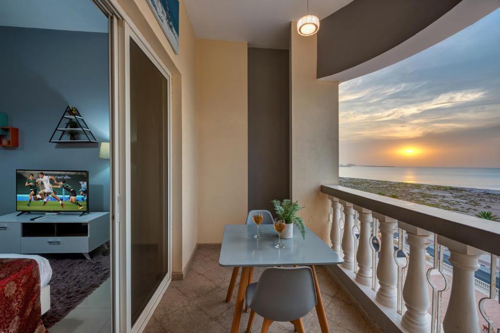 a room with a balcony with a view of the ocean at Kay Homes Royal Studio in Ras al Khaimah