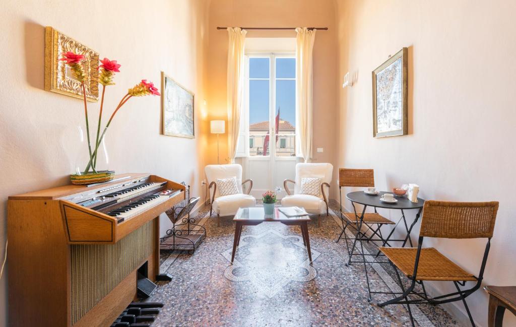 a living room with a piano and a table and chairs at La Torre Garbata in Pisa