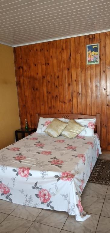 een slaapkamer met een bed met roze bloemen erop bij Pousada Belvedere in Tibagi