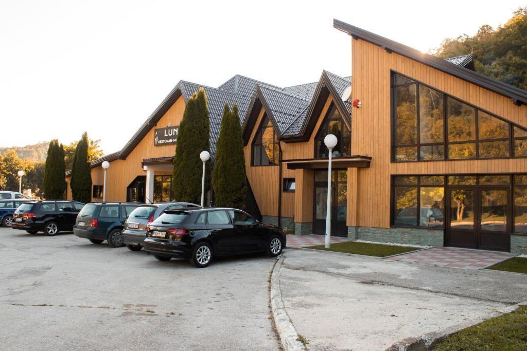 un parking avec des voitures garées devant un bâtiment dans l'établissement Odmorište Luna, à Olovo