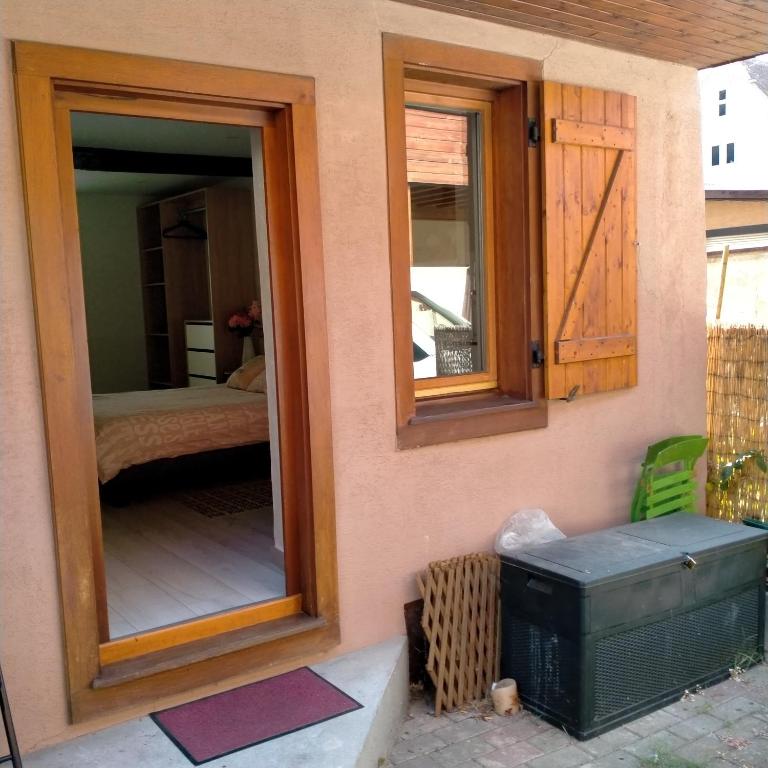 a house with a window and a bedroom with a bed at Passage des Romains studio in Horbourg