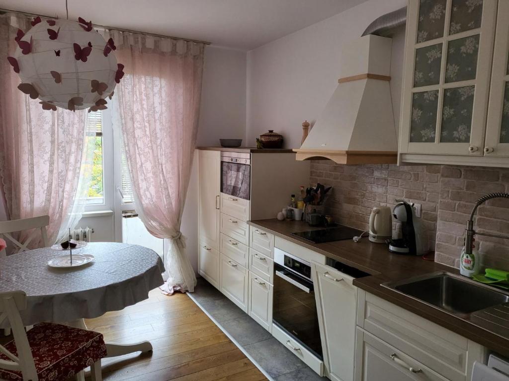 a kitchen with white cabinets and a table and a window at CasaBella Apartment in Sofia