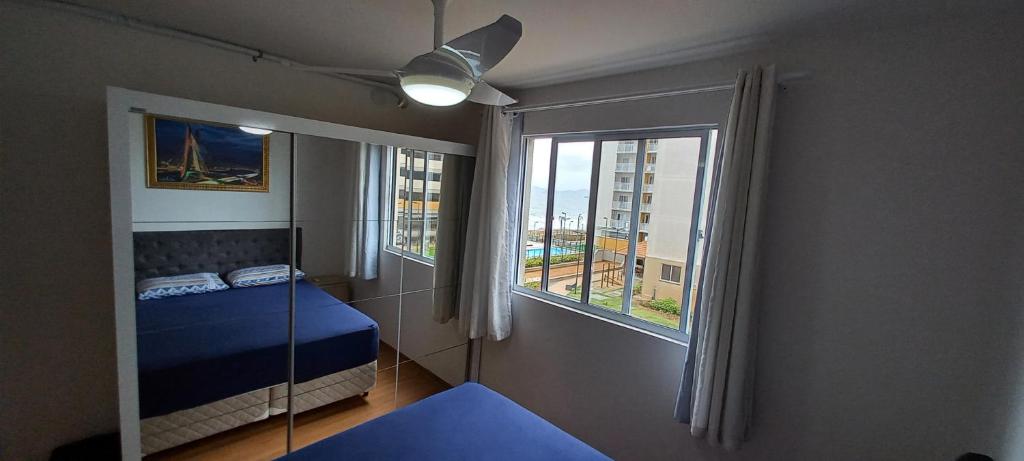 a bedroom with a bed and a large window at Apartamento CONFORT CLUB FRENTE MAR completo. in Barra Velha