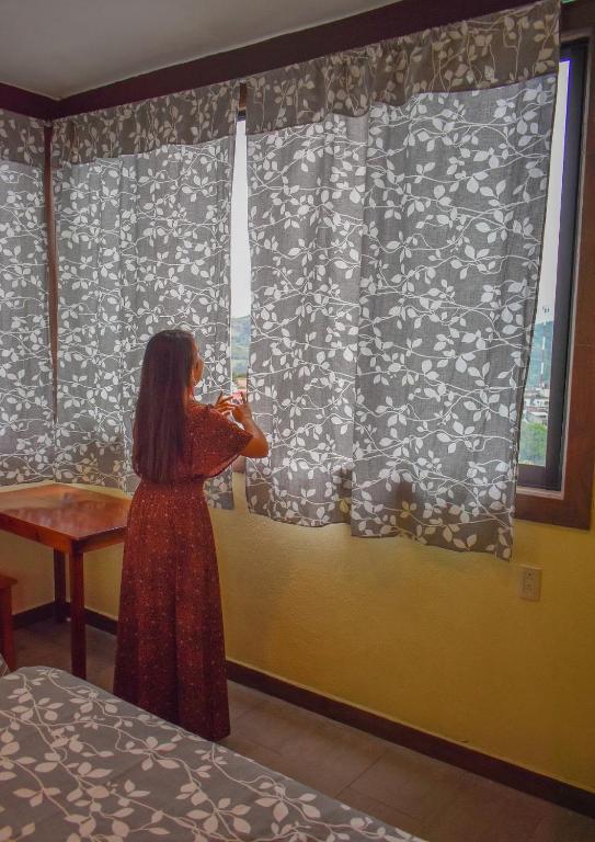 a woman standing in front of a window taking a picture at Casa Jhada-Xilitla in Xilitla