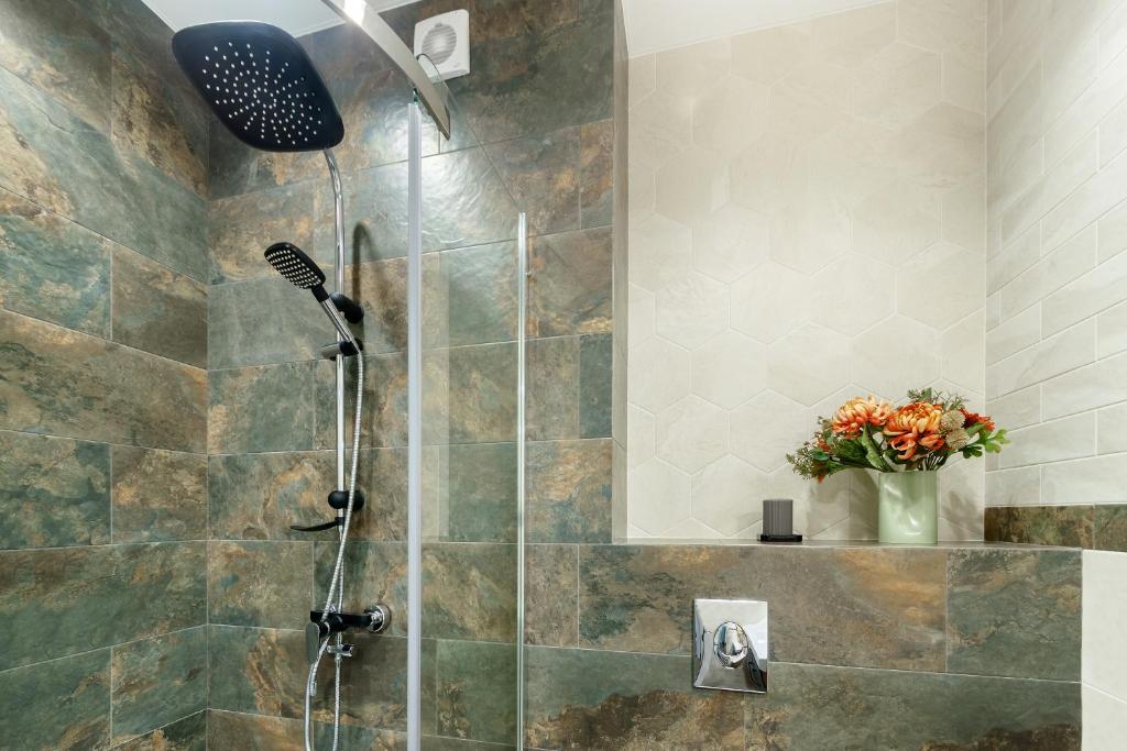 a shower with a shower head in a bathroom at LUX Apartments on Soborniy lane in Rostov on Don