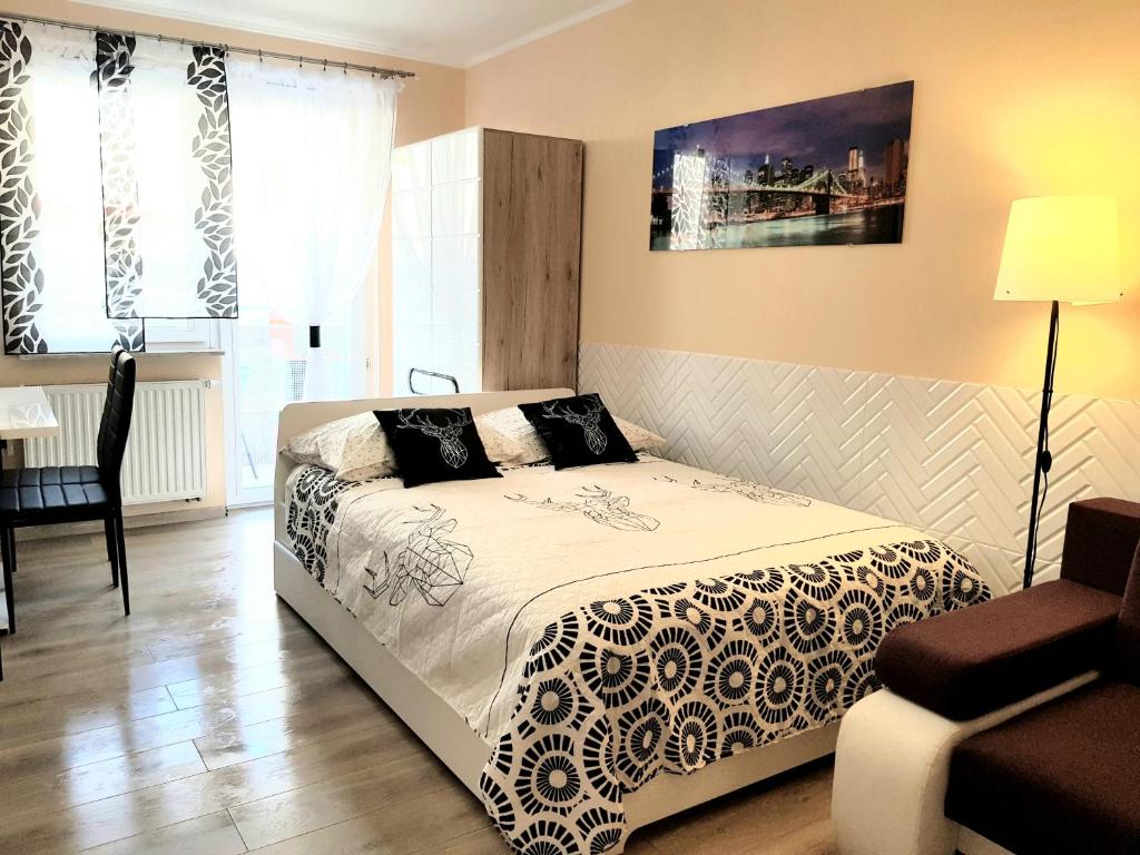 ein Schlafzimmer mit einem Bett, einem Tisch und einem Stuhl in der Unterkunft Apartment GLAMOUR Downtown balcony in Krakau