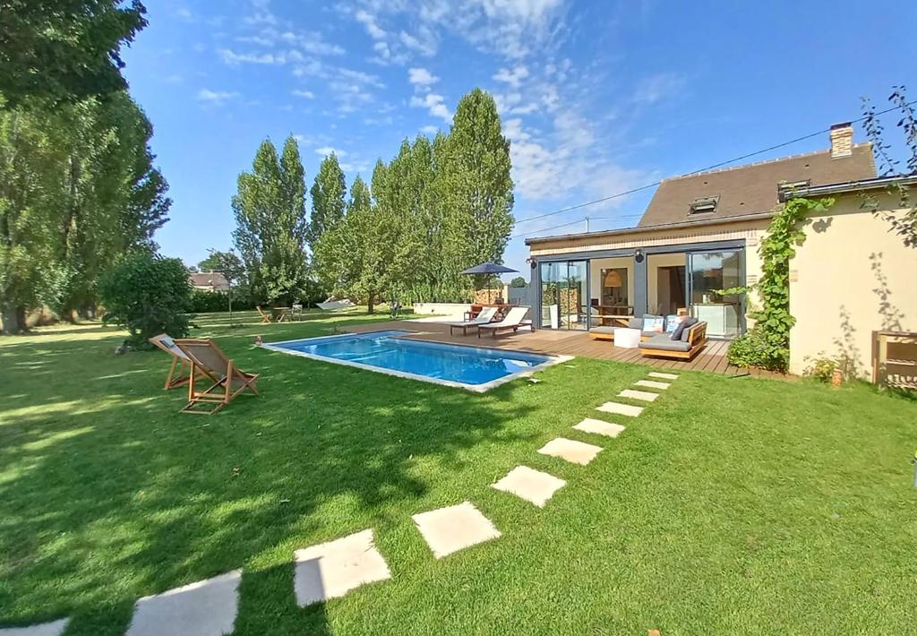 un patio con piscina y una casa en Paradis des champs 1h30 de Paris au cœur du Perche, en Neuilly-sur-Eure