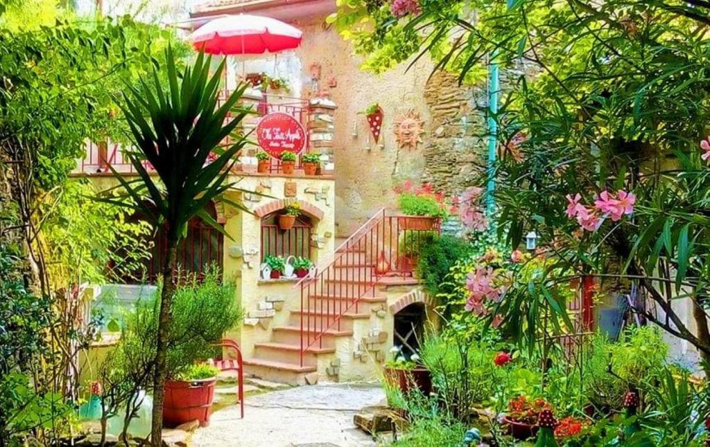 un jardín con escalera y un edificio con plantas en The Four Angels en Massa