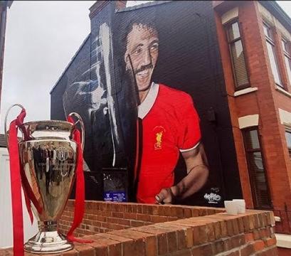 une fresque d'un joueur de football sur un bâtiment avec un trophée dans l'établissement Dinorwic Lodge, à Liverpool