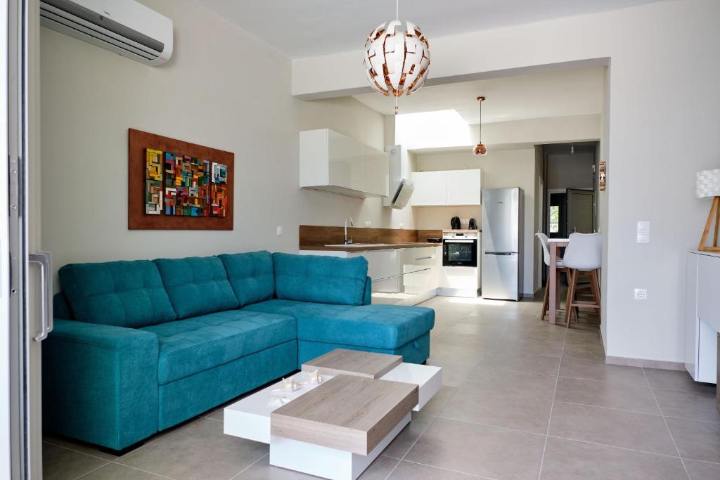 een woonkamer met een blauwe bank en een keuken bij Mirtos Luxury apartment in Myrtos