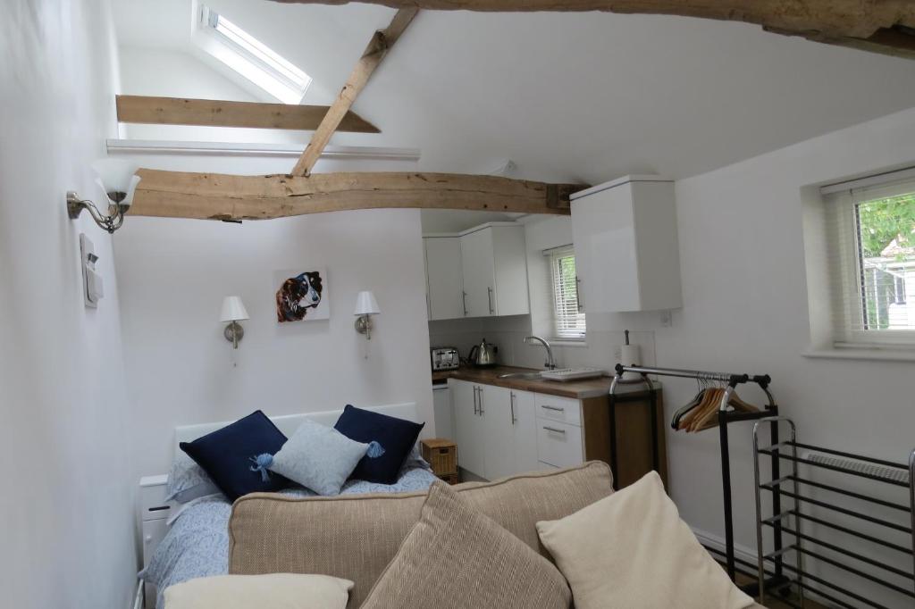 a living room with a couch and a kitchen at The Old Stables, Whitehall Farmhouse, Oakington in Cambridge