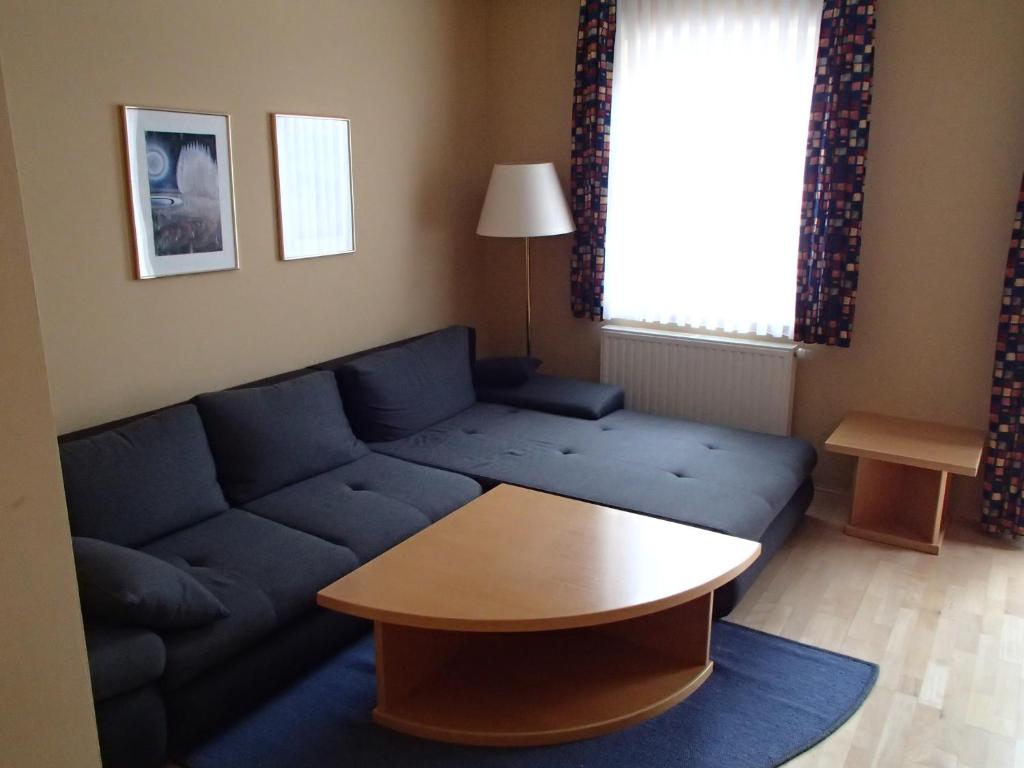 salon z niebieską kanapą i stołem w obiekcie Ferienhaus Lutzmannsburg mit direktem Thermenzugang und eigenem Garten w mieście Lutzmannsburg