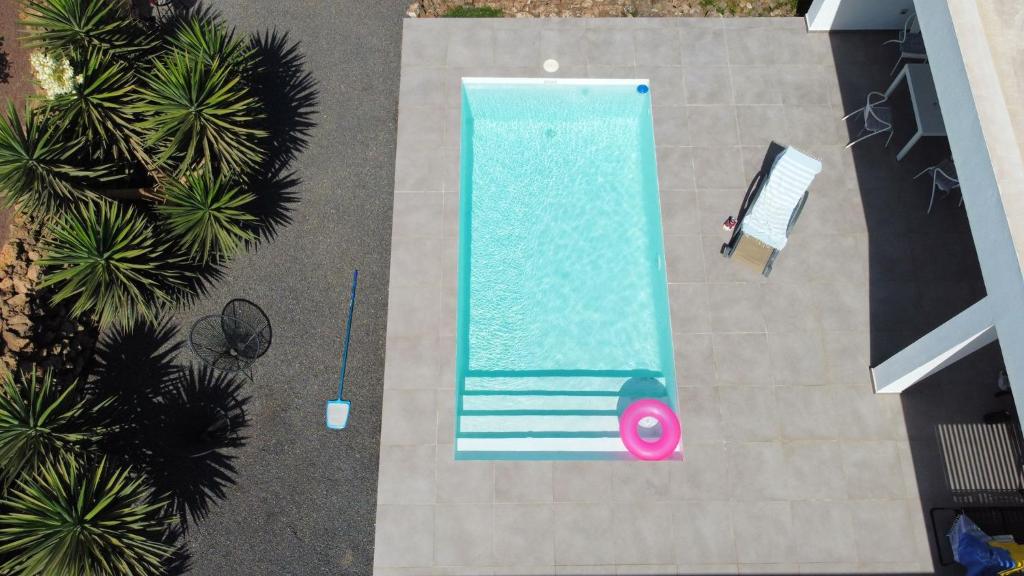 an overhead view of a swimming pool with a person next to it at Villa Montaña Colorada in Lajares