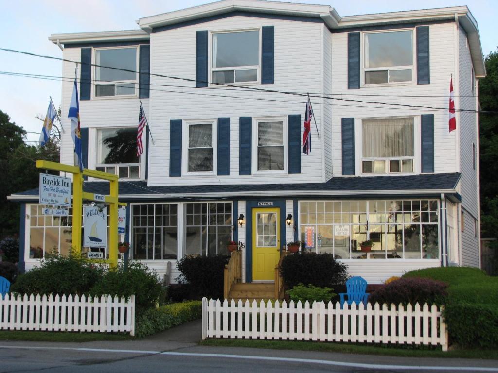 a house with a white fence in front of it at Bayside Inn in Digby