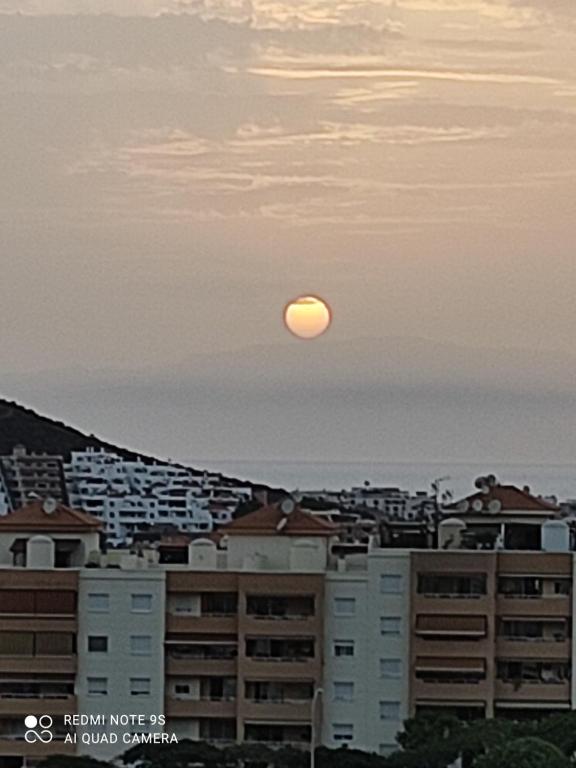 Pełnia księżyca wznosi się nad miastem z budynkami w obiekcie Castle HARBOUR 425 w mieście Los Cristianos
